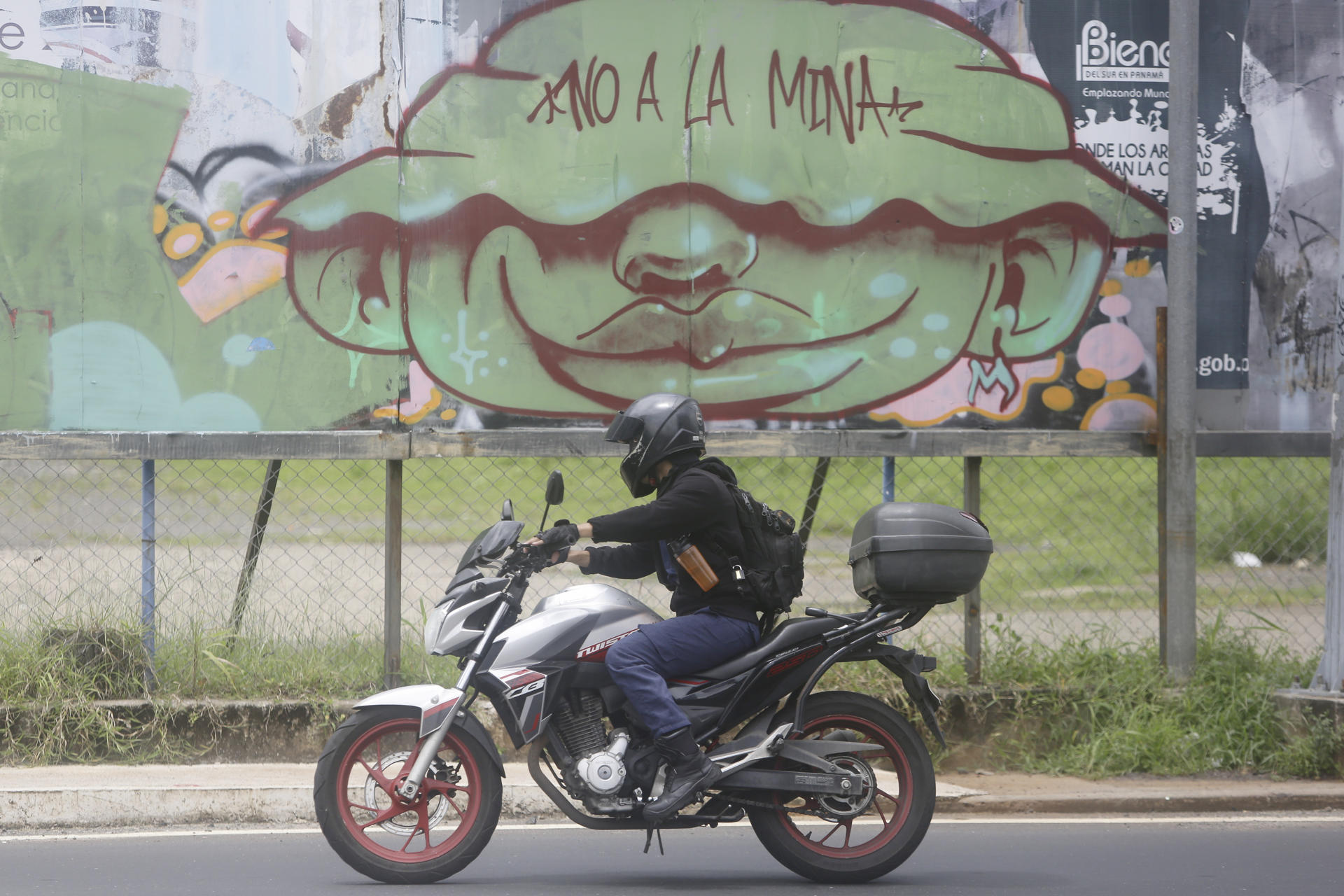 Una persona transita frente a un grafiti contra la minería este jueves, en Ciudad de Panamá (Panamá). EFE/ Carlos Lemos
