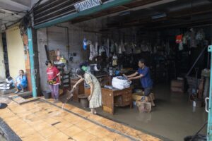 Unas personas limpian su tienda tras las inundaciones en Depansar, Bali (Indonesia) este miércoles. EFE/EPA/MADE NAGI