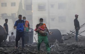 Imagen de archivo de un palestino que carga a una niña herida tras recuperarla de los escombros de una zona destruida tras los ataques aéreos israelíes en la ciudad de Gaza. EFE/EPA/MOHAMMED SABLE