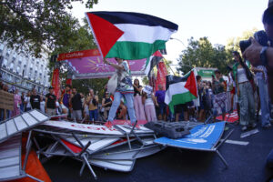 Los manifestantes propalestinos cortan el recorrido de los ciclistas en el Paseo del Prado, este domingo, durante la última etapa de la Vuelta a España que se disputa entre las localidades madrileñas de Alalpardo y Madrid, con un recorrido 103,6 Km.- EFE/Rodrigo Jiménez