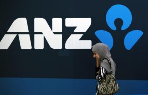Foto de archivo de una mujer que camina junto al logotipo del banco australiano y neozelandés ANZ en su sede en Sídney (Australia). EFE/Daniel Munoz