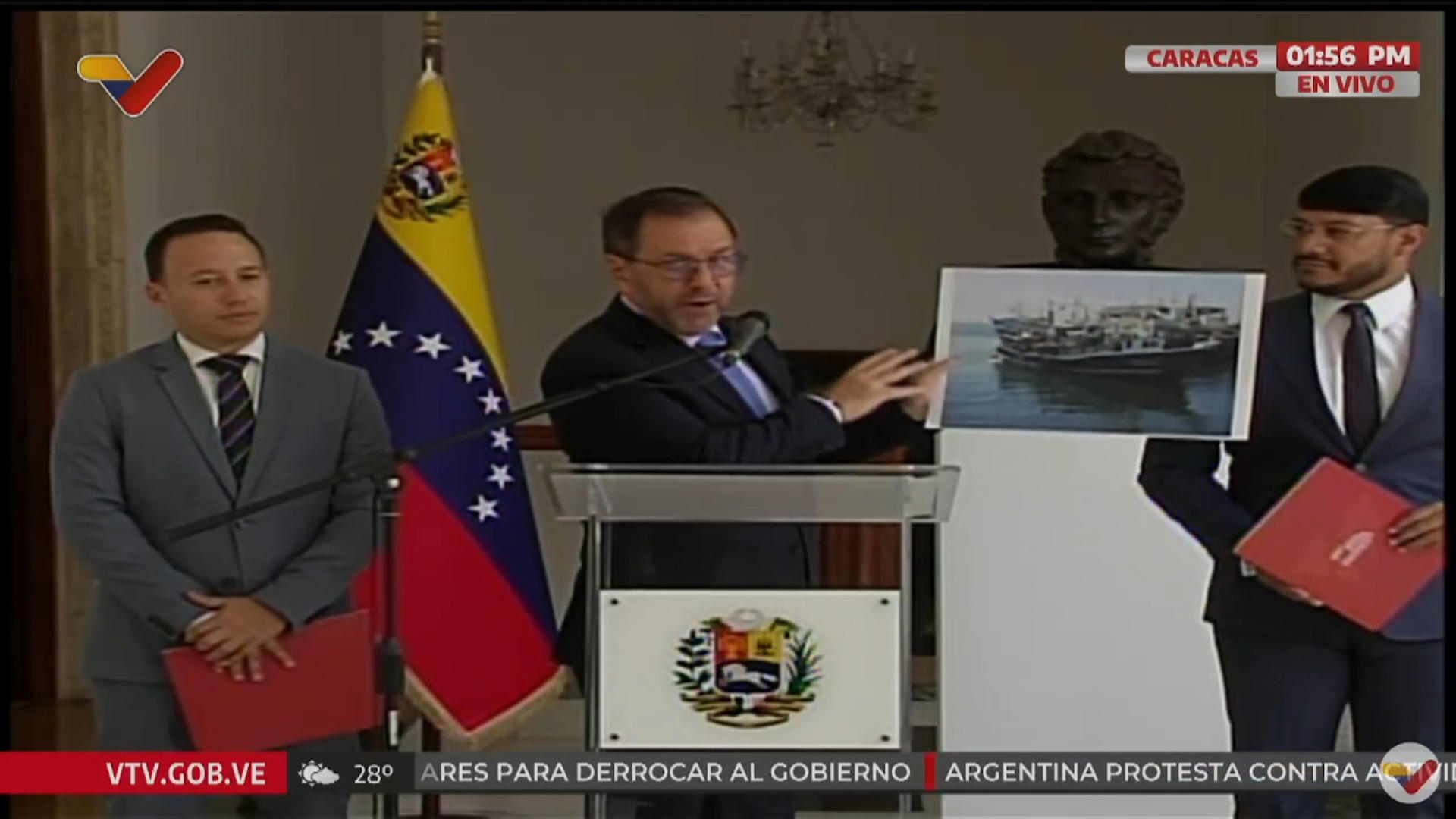Captura de video cedido por VTV que muestra al canciller de Venezuela, Yván Gil (c), sosteniendo la imagen de una embarcación este sábado, en Caracas (Venezuela).EFE/ VTV