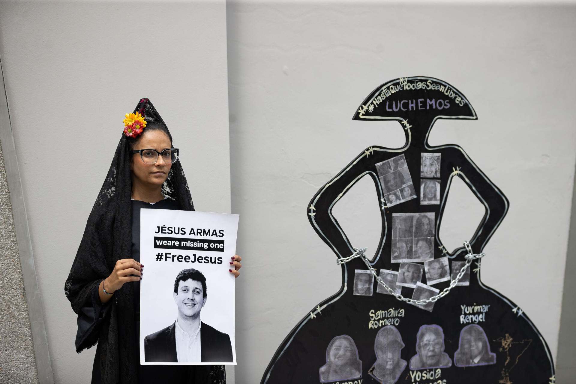 Una mujer sostiene un cartel durante una concentración por los presos políticos este lunes, frente a la sede de la embajada de España en Caracas (Venezuela). EFE/ Ronald Pena R
