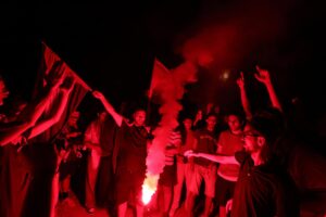 Partidarios propalestinos encienden bengalas mientras asisten a una manifestación para protestar por un ataque al barco humanitario Al-Dhamir, frente a la costa en el puerto de Sidi Bou Said, Túnez. EFE/MOHAMED MESSARA