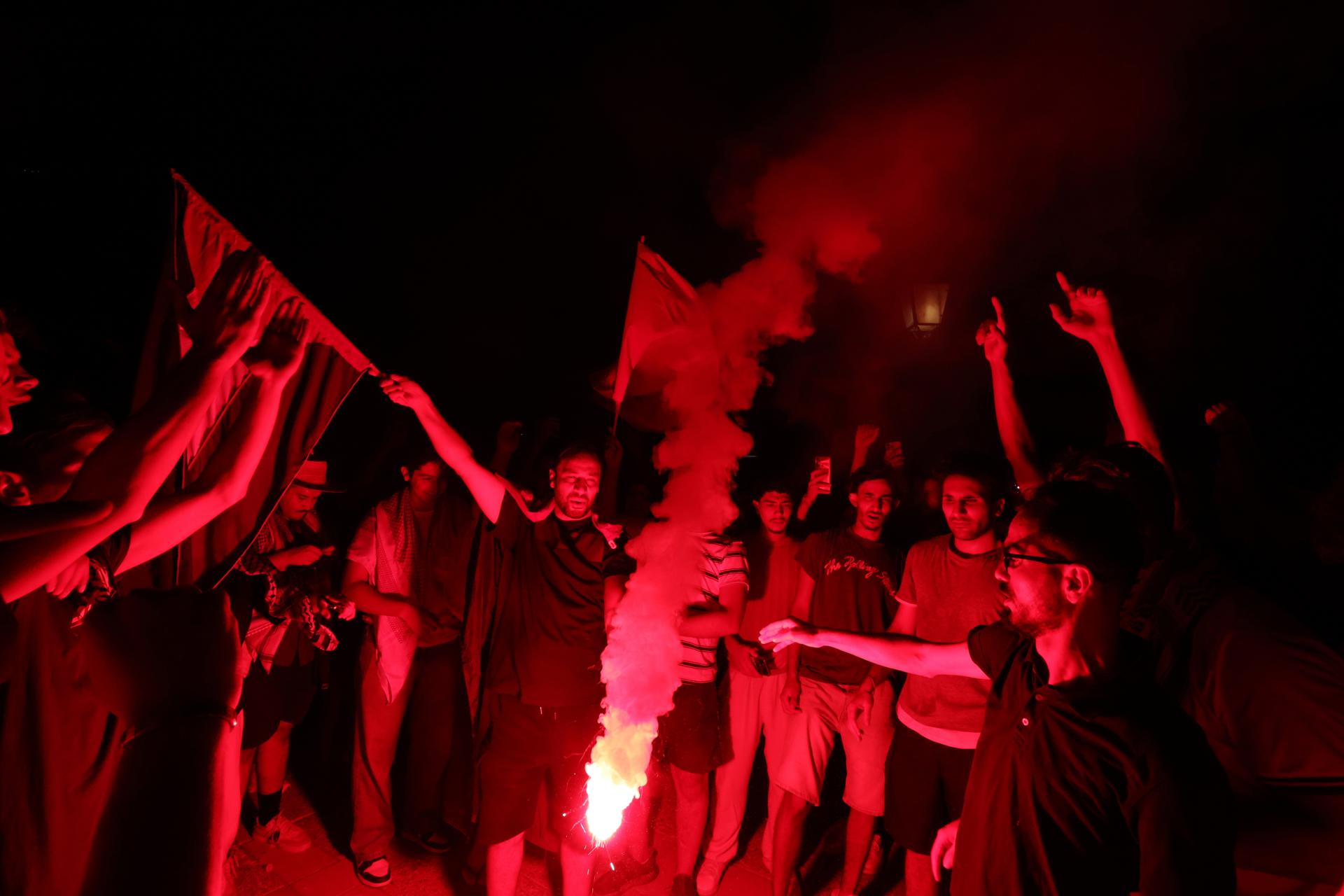 Partidarios propalestinos encienden bengalas mientras asisten a una manifestación para protestar por un ataque al barco humanitario Al-Dhamir, frente a la costa en el puerto de Sidi Bou Said, Túnez. EFE/MOHAMED MESSARA