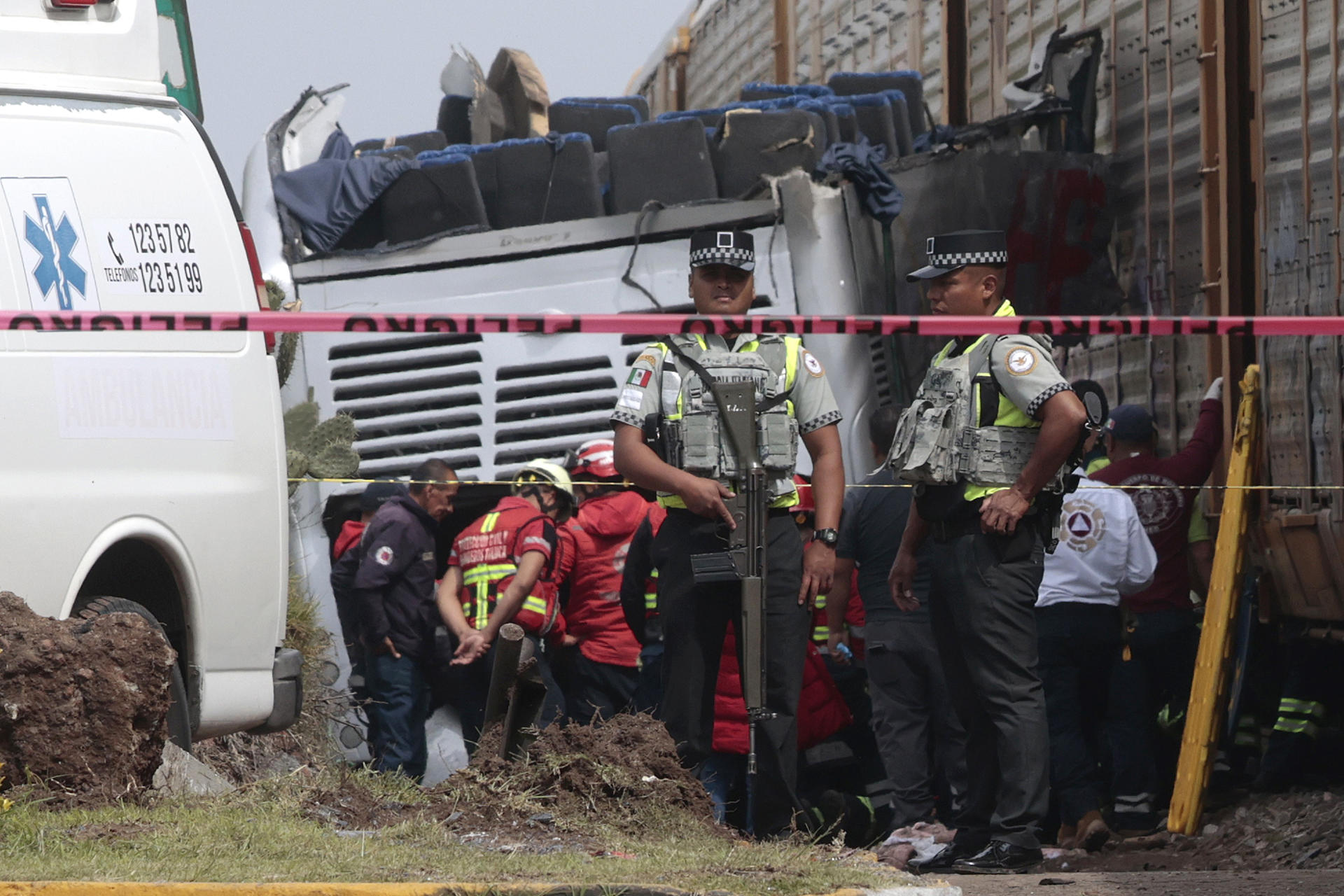 Integrantes de Policía resguardan la zona donde ocurrió el accidente entre un ferrocarril y un autobús este lunes, en Atlacomulco (México). EFE/Felipe Gutiérrez