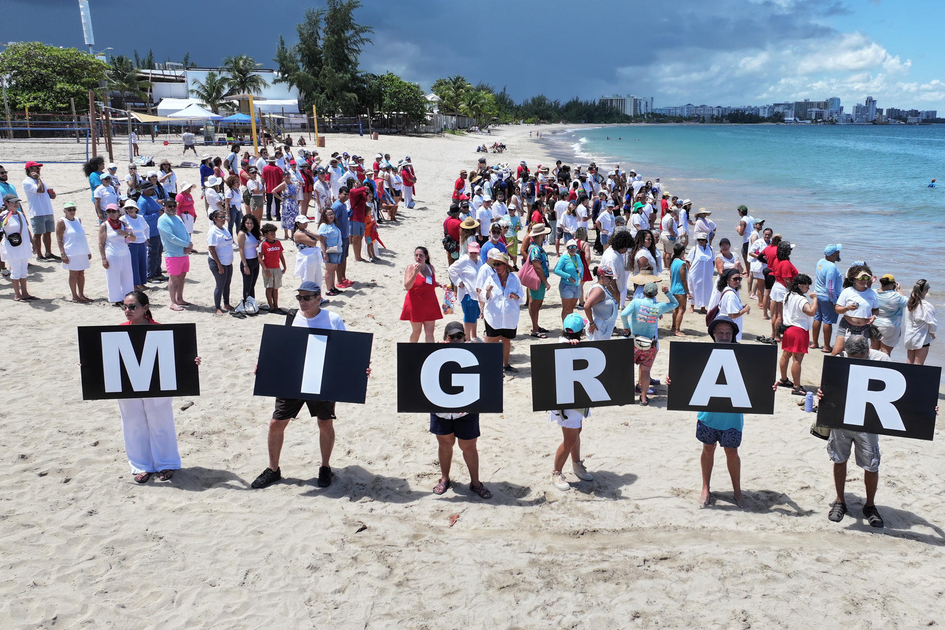 Fotografía cedida por las organizaciones Kilómetro 0, Amnistía Internacional de Puerto Rico, Comuna Caribe y la Unión Americana de Libertades Civiles (ACLU, en Inglés) que muestra a personas formando durante una manifestación este sábado, en la playa balneario de Carolina (Puerto Rico). EFE/ Kilómetro 0/ Amnistía Internacional de Puerto Rico/ Comuna Caribe/ACLU
