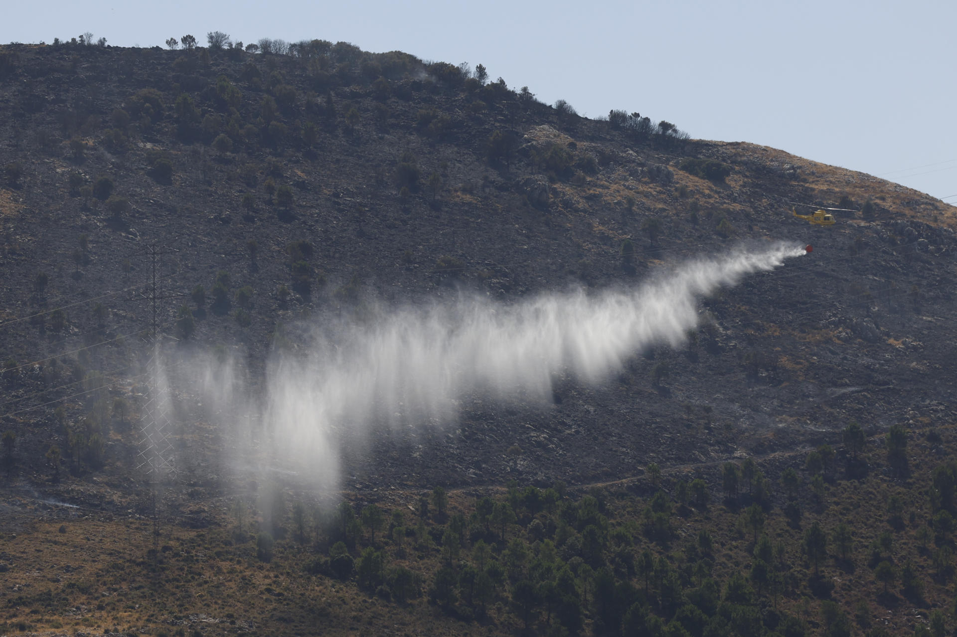 Medios aéreos entre aviones y helicópteros luchan contra el incendio forestal activo en el paraje Cortijo El Navazo, en el municipio malagueño de Parauta, ubicado en la Serranía de Ronda. EFE/Jorge Zapata
