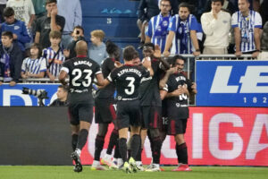 El delantero chileno del Sevilla FC Alexis Sánchez (d) celebra con sus compañeros tras anotar un gol durante el partido de la quinta jornada de LaLiga EA Sports disputado en el estadio de Mendizorroza, en Vitoria. EFE/L. Rico