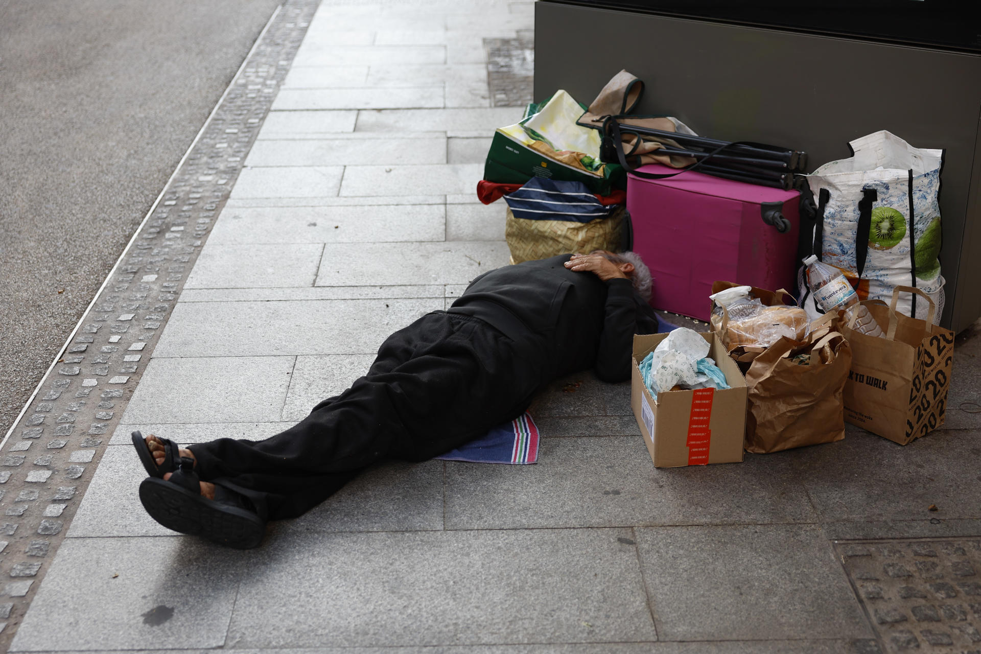 Una persona duerme en la calle rodeada de sus escasas pertenencias en julio último en Madrid. EFE/ Mariscal