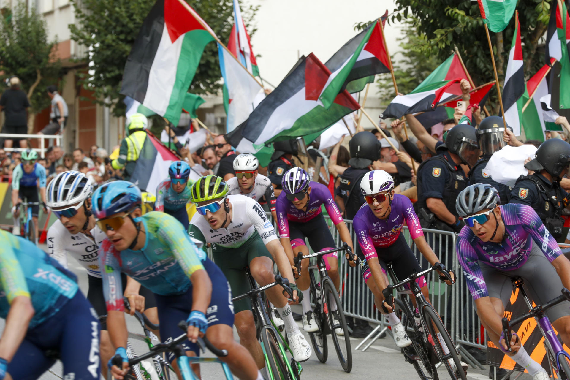 Manifestantes propalestinos protestan durante la decimoquinta etapa de la Vuelta ciclista a España que se disputa este domingo entre Vegadeo (Asturias) y Monforte de Lemos (Lugo) sobre un recorrido de 167,8 kilómetros. EFE/ Eliseo Trigo