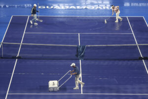 Trabajadores secan la cancha este lunes, previo a reanudar el partido del torneo Guadalajara Open WTA 500 entre la griega Maria Sakkari y la francesa Elsa Jacquemot en el Centro Panamericano de Tenis, en Guadalajara (México). EFE/Francisco Guasco