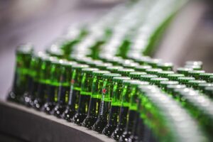Botellas de cerveza en la cinta transportadora de la línea de envasado de la compañía Heineken, en una fotografía de archivo. EFE/FREEK VAN DEN BERGH