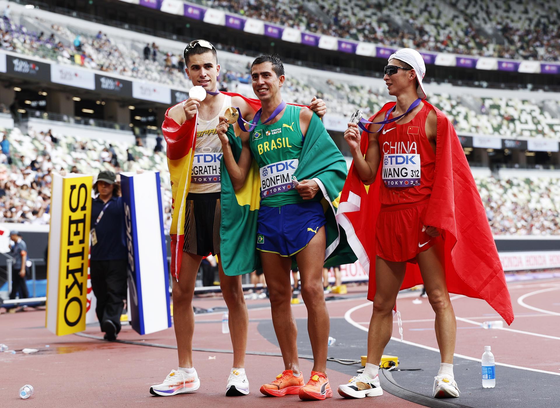 El español Paul McGrath (i) exhibe la medalla de bronce obtenida este sábado en los 20 kilómetros marcha de los Mundiales de Tokio junto al ganador de la prueba, el brasileño Caio Bonfim of Brazil (c) y el chino Zhaozhao Wang (d), ganador de la plata. EFE/EPA/FRANCK ROBICHON