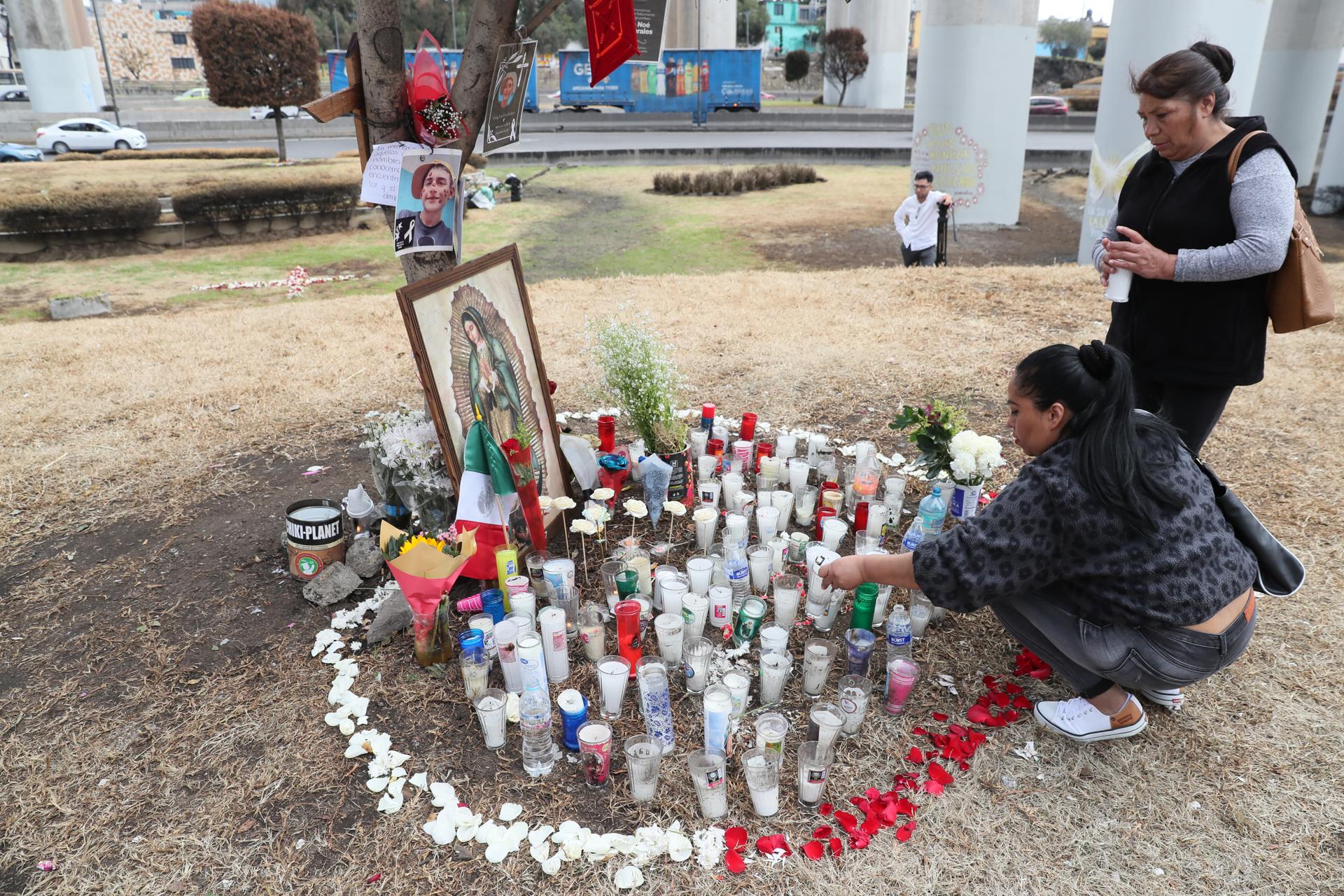 Personas encienden velas en un altar en la zona donde ocurrió la explosión de un camión de gas en Ciudad de México (México). EFE/ Mario Guzmán