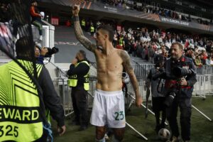 El futbolista del Roma Gianluca Mancini (C) celebra junto a los aficionados de su equipo el triunfo en el partido de la Liga Europa contra el Niza, disputado este miércoles. EFE/SEBASTIEN NOGIER
