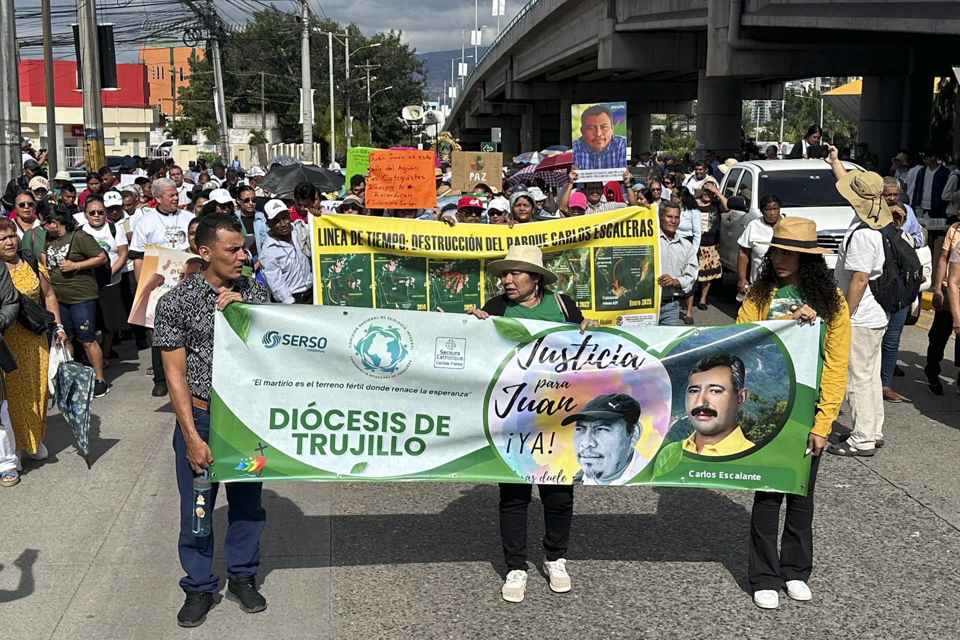 Personas sostienen carteles con la imagen del ambientalista hondureño Juan López durante una peregrinación este sábado, en Tegucigalpa (Honduras). EFE/Germán Reyes
