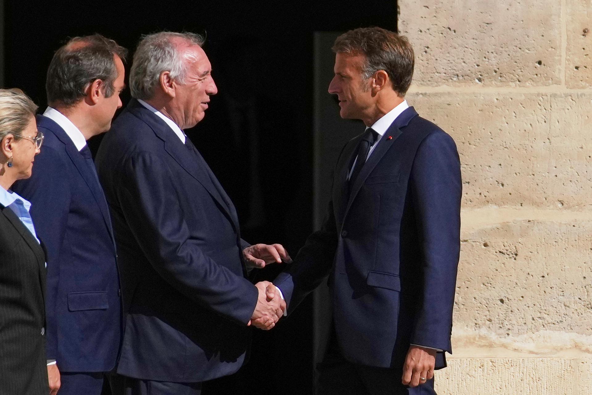 El presidente francés, Emmanuel Macron (R), estrecha la mano del primer ministro, François Bayrou, durante la ceremonia de despedida del jefe de Estado Mayor de las Fuerzas Armadas francesas Thierry Burkhard, en el patio de los Inválidos, en París, Francia, 05 de septiembre de 2025. (Francia) EFE/EPA/CHRISTOPHE ENA / POOL MAXPPP OUT