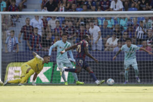 El delantero del Levante Karl Eyong y el portero del Betis Álvaro Vallés, durante el partido de la jornada 4 de LaLiga EA Sports entre el Levante y el Betis, este domingo en el estadio gol Ciutat de València.- EFE/ Manuel Bruque