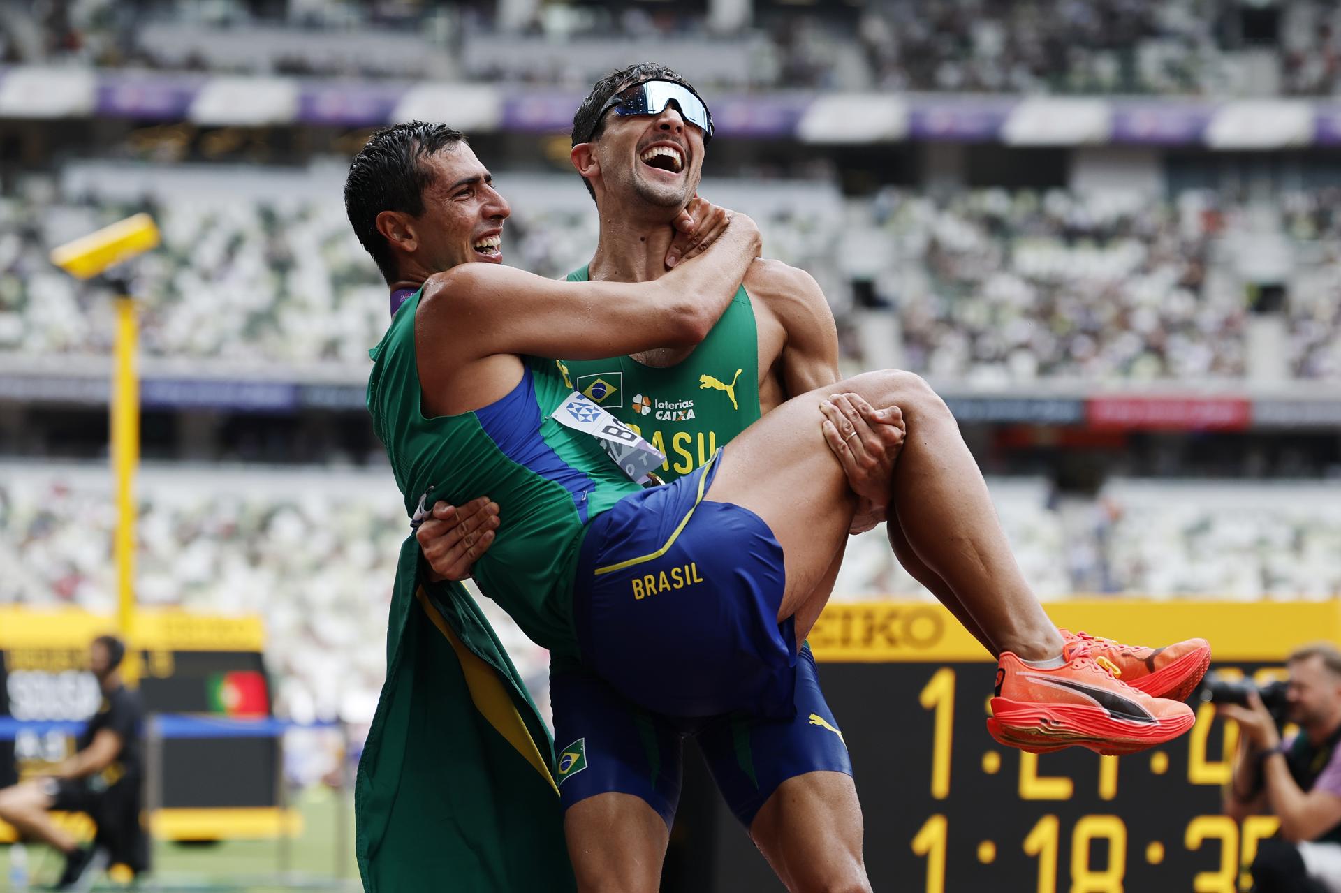 El atleta brasileño Caio Bonfim, quien es cargadado por su compatriota Matheus Correa tras consagrase este sábado en Tokio como campeón del mundo de 20 kilómetros marcha, confesó que perdió el anillo de boda en el kilómetro 3 de la prueba. EFE/EPA/MAST IRHAM