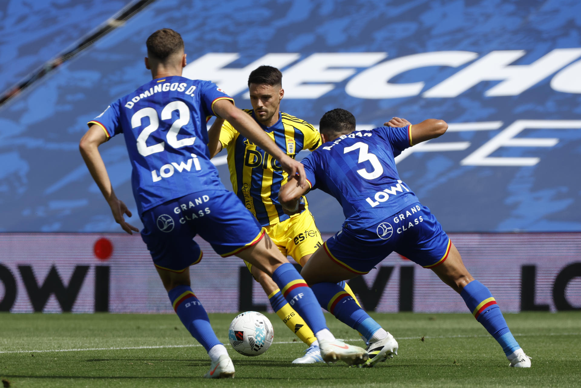 Los jugadores del Getafe CF Domingos de Sousa (i) y Abdel Abqar (d) intentan evitar el avance del centrocampista croata Josip Brekalo (c), del Real Oviedo, durante su partido de LaLiga EA Sports disputado este sábado en el Estadio Coliseum de Getafe. EFE/ J.J. Guillén
