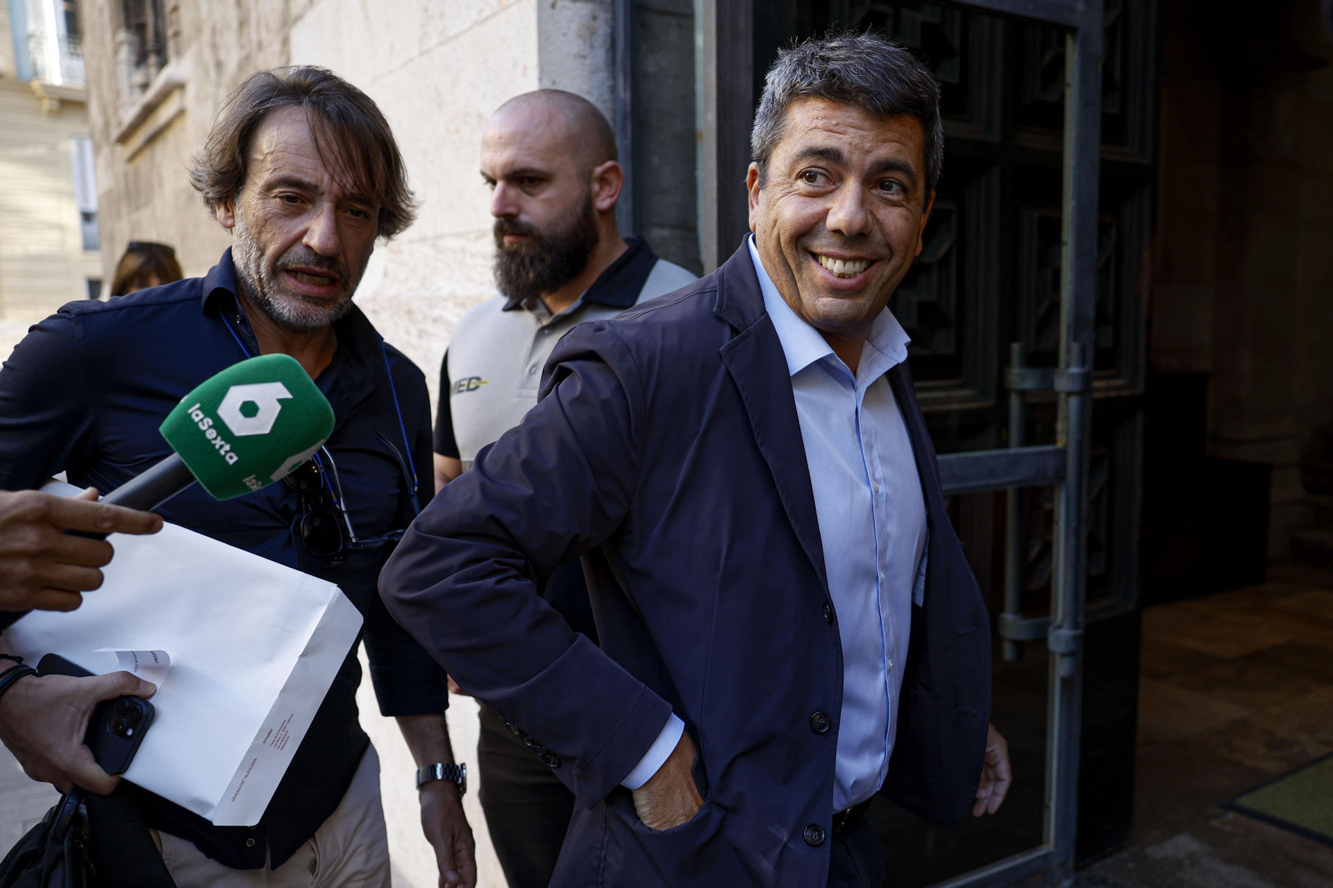 El presidente de la Generalitat, Carlos Mazón, a su llegada este jueves al Palau de la Generalitat donde preside el pleno del Gobierno valenciano que tiene previsto aprobar, entre otros asuntos, el primer pliego en España para construir unas 80 viviendas industrializadas que irán destinadas a personas afectadas por la dana de Torrent y Albal. EFE/Biel Aliño
