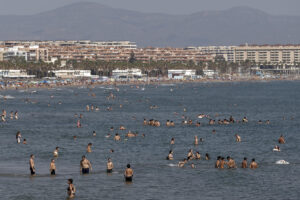 Un gran número de personas se refresca en aguas de la playa de la Malvarrosa durante este lunes. EFE/Manuel Bruque