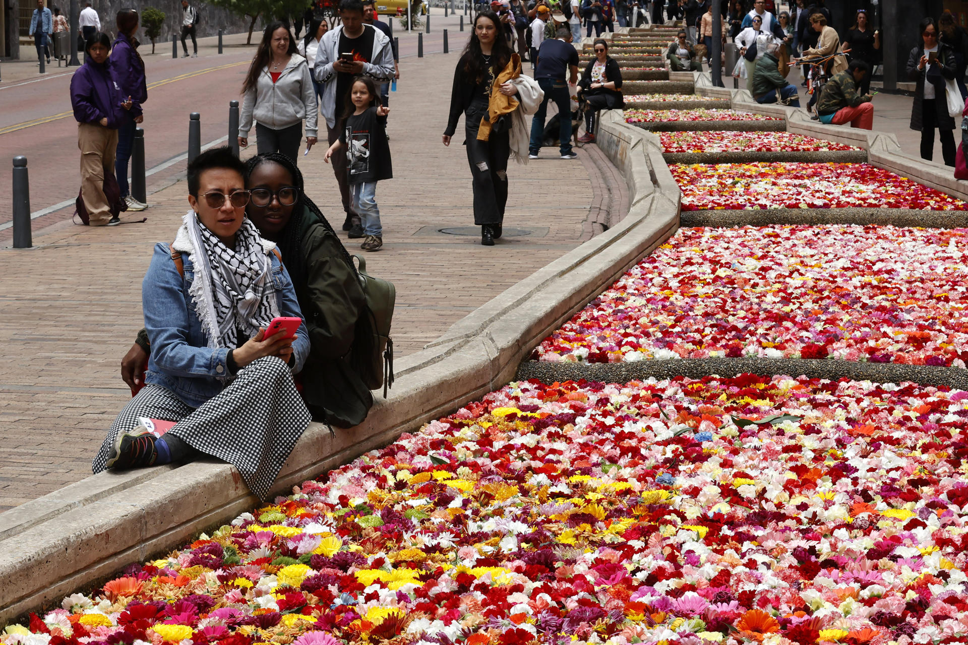 Personas observan un río con 150.000 flores en el eje ambiental, como antesala de la inauguración de la primera edición de la Bienal Internacional de Arte y Ciudad BOG25 este sábado, en Bogotá (Colombia). EFE/ Mauricio Dueñas Castañeda
