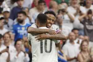 El defensa brasilero del Real Madrid Éder Gabriel Militão (detrás) celebra con Kylian Mbappé el primer gol conseguido ante el RCD Espanyol, durante el partido de la jornada 5 de LaLiga EA Sports, que disputan el Real Madrid y el RCD Espanyol, en el estadio Santiago Bernabéu de la capital española. EFE/Sergio Pérez