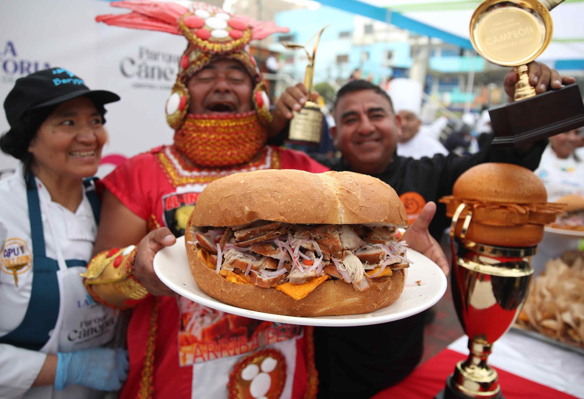 Una persona sostiene panes con chicharrón este jueves, en Lima (Perú). EFE/Paolo Aguilar
