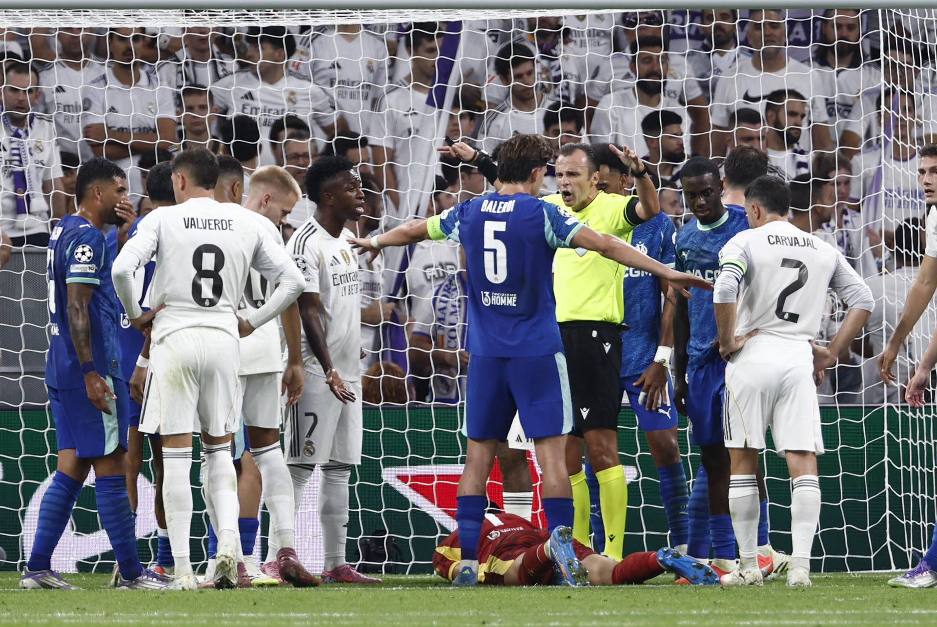 El defensa del Olympique Leonardo Balerdi (3-d) conversa con el árbitro Dennnis Higler (2-d), durante el partido de la primera jornada de la Liga de Campeones que Real Madrid y Olympique de Marsella disputan en el estadio Santiago Bernabéu. EFE/Daniel González
