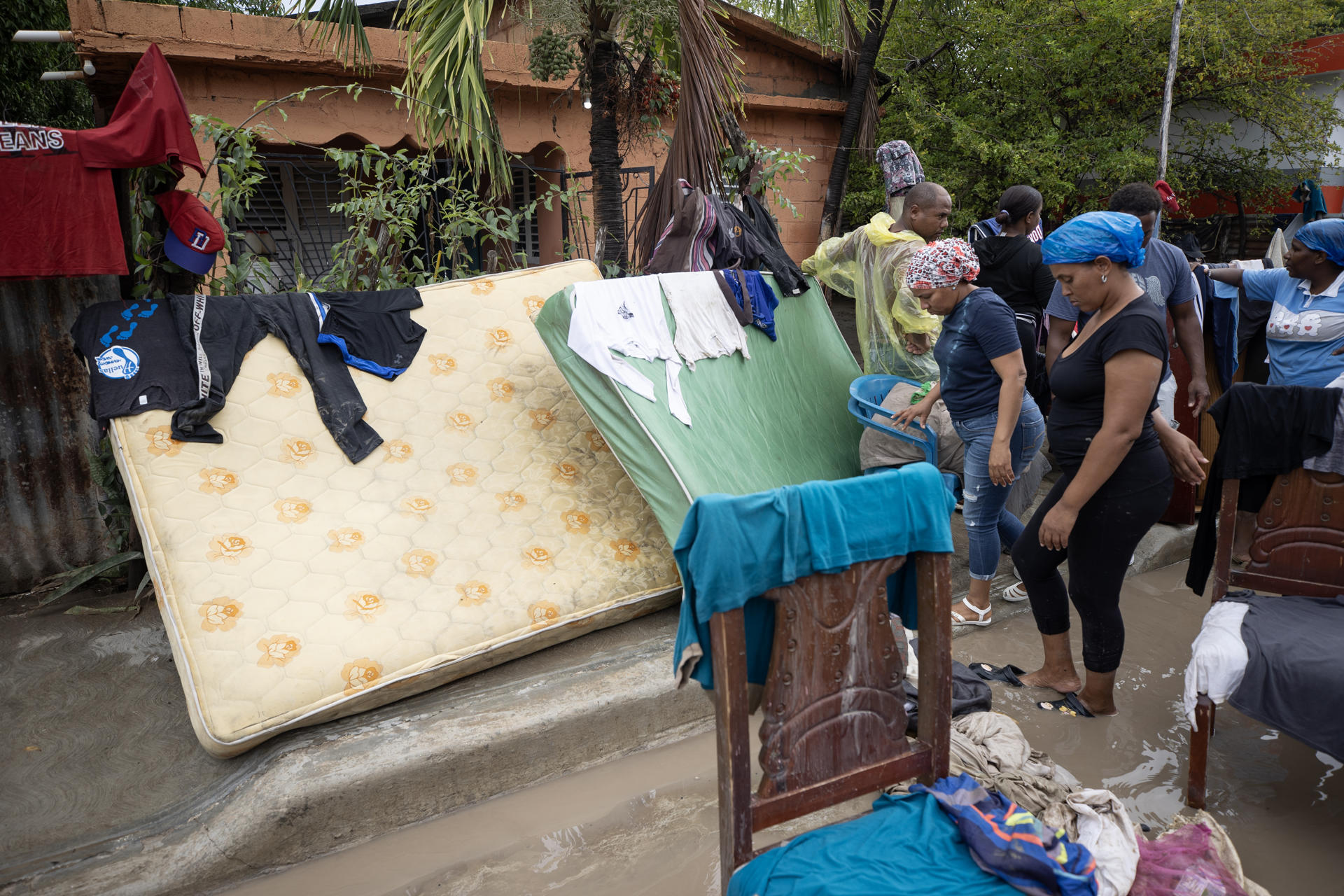 Personas secan sus pertenencias luego de una inundación este viernes, en Azua (República Dominicana). EFE/ Orlando Barría
