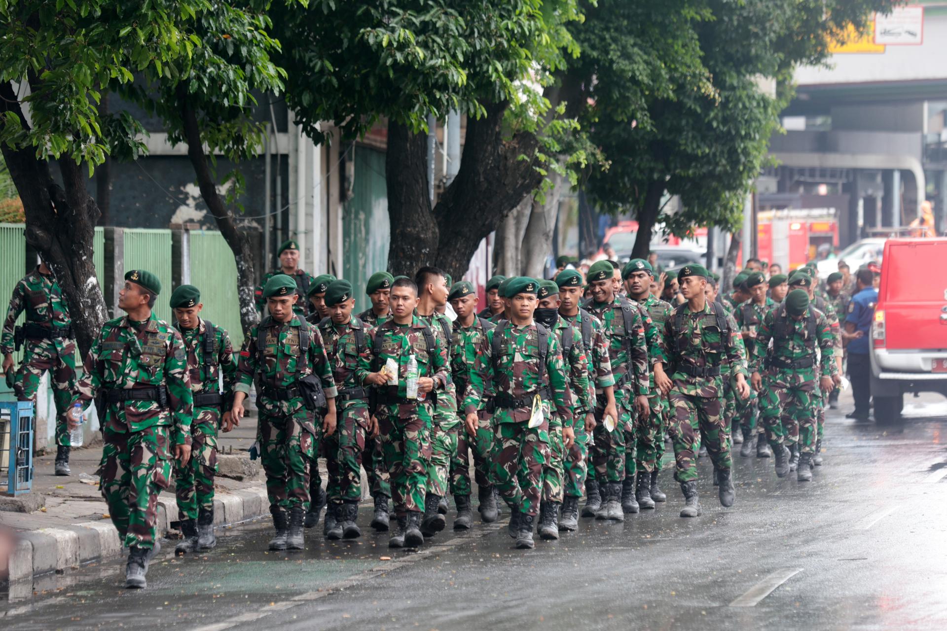 YAKARTA (Indonesia), 31/08/2025.- Soldados indonesios caminan frente a la sede de la brigada móvil de policía en medio de las protestas en Yakarta, Indonesia. EFE/EPA/ADI WEDA