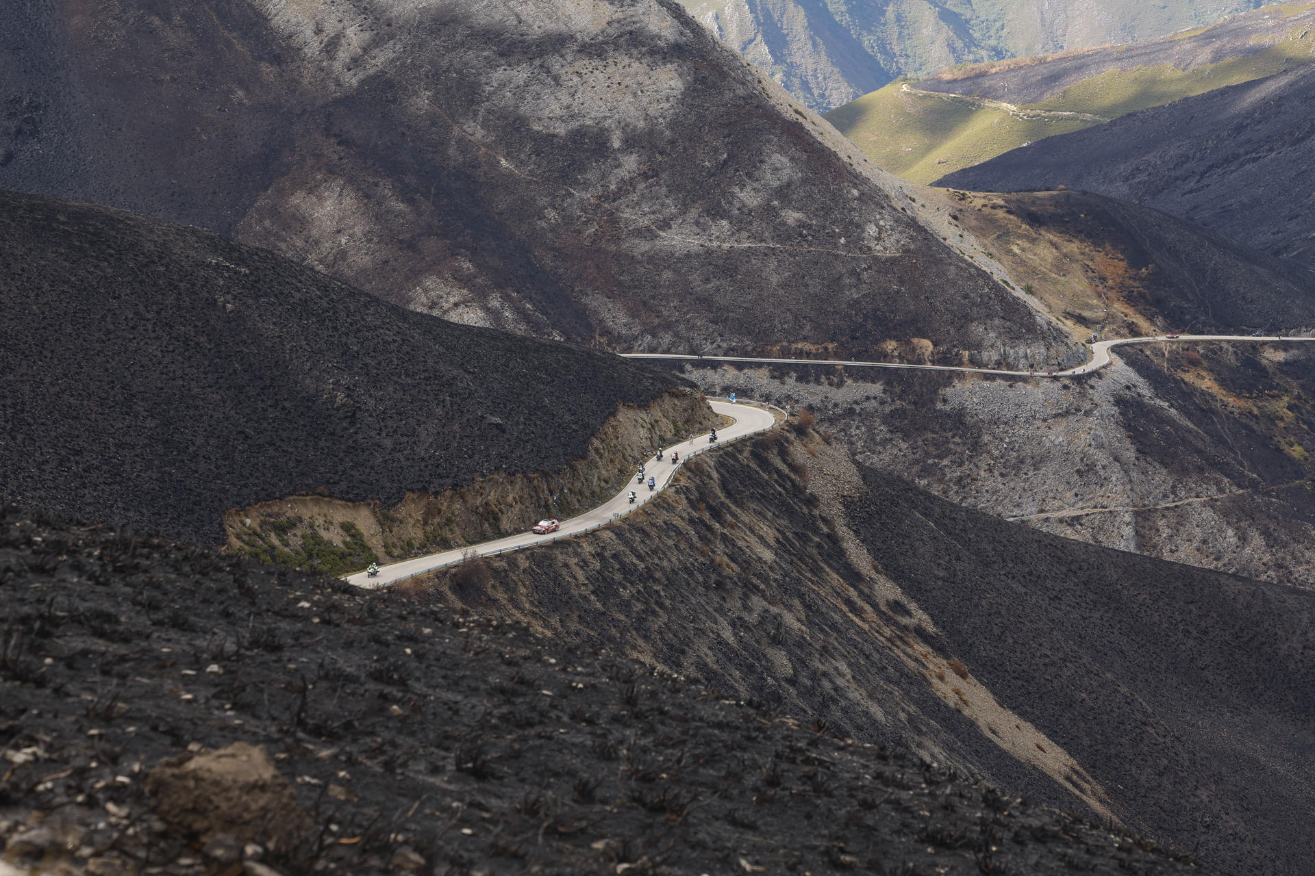 Los ciclistas recorren el paisaje calcinado por los incendios en el Bierzo durante la etapa 17 de la Vuelta Ciclista a España disputada este miércoles entre O Barco de Valdeorras (Ourense) y Alto de El Morredero (EL Bierzo-León), de 143,2km de recorrido. EFE/Javier Lizón