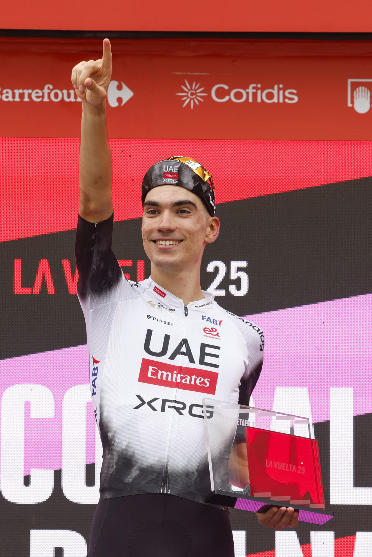 El ciclista español del Emirates UAE Juan Ayuso,celebra en el podio la victoria conseguida en la duodécima etapa de la Vuelta Ciclista a España 2025 este jueves en Los Corrales de Buelna (Cantabria). EFE/Javier Lizón