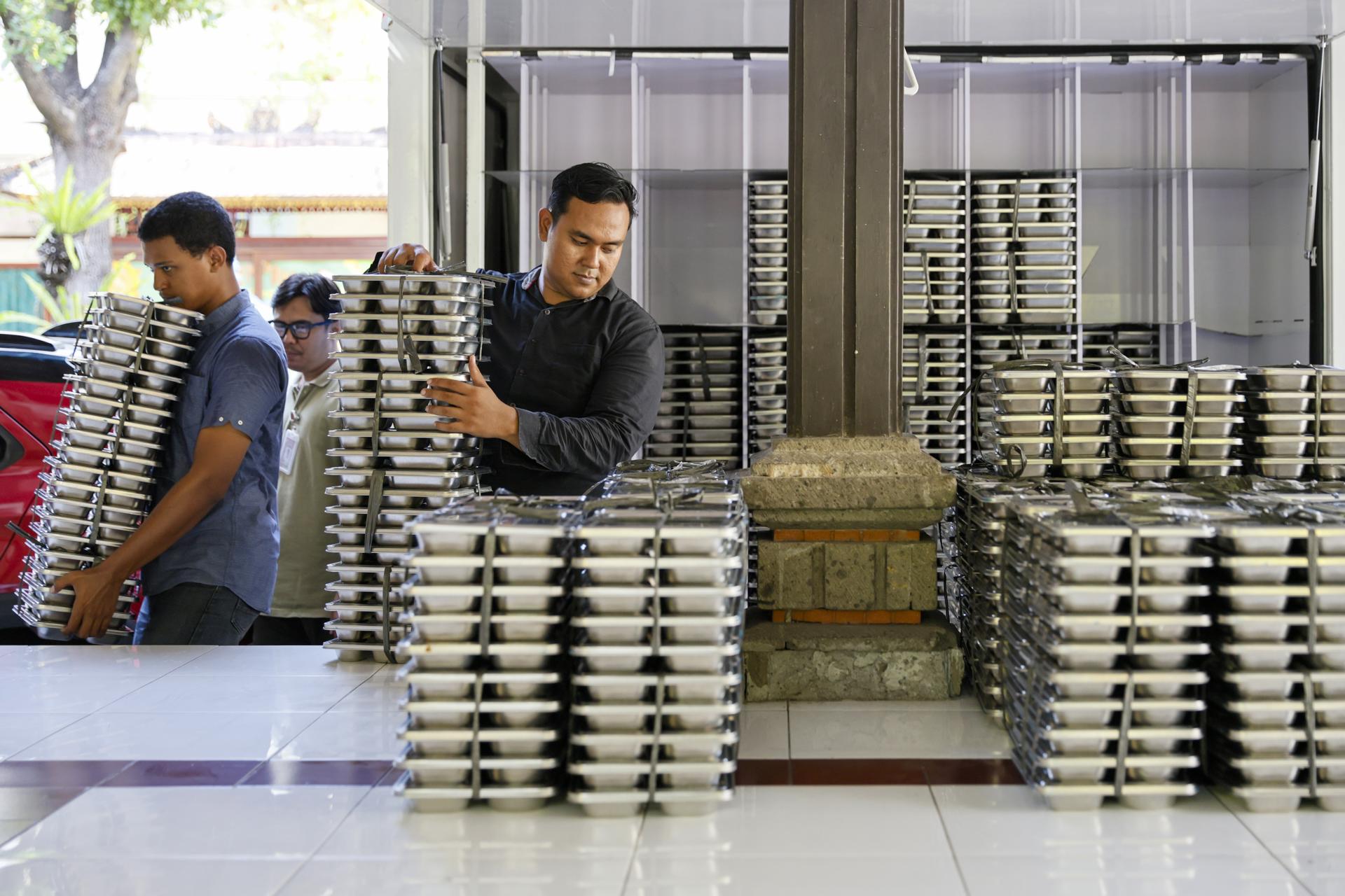 DENPASAR (Indonesia), 26/09/2025.- Trabajadores distribuyen comidas gratuitas en una escuela secundaria en Denpasar, Bali, Indonesia, en el marco del programa gubernamental que ha causado cerca de 6.000 intoxicaciones alimentarias, según la Agencia Nacional de Nutrición del país. EFE/EPA/MADE NAGI
