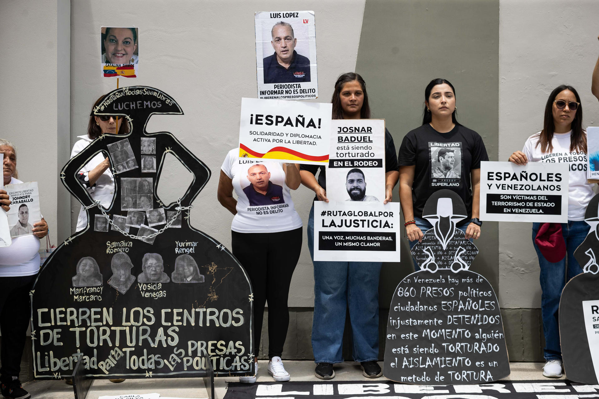 Personas sostienen carteles durante una concentración por los presos políticos este lunes, frente a la sede de la embajada de España en Caracas (Venezuela).EFE/ Ronald Pena R

