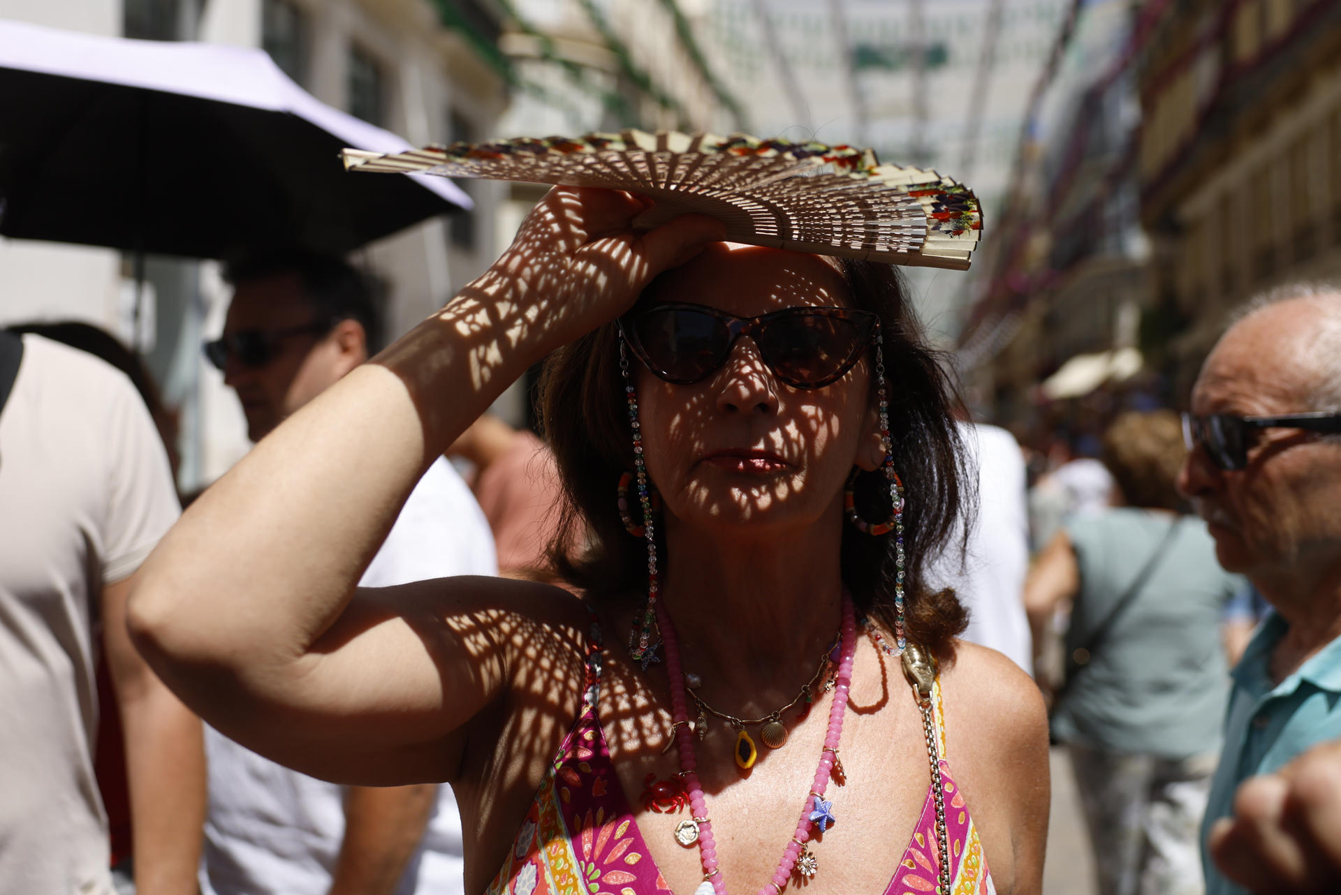 Imagen de archivo de una mujer resguardándose del sol con un abanico. EFE/Jorge Zapata