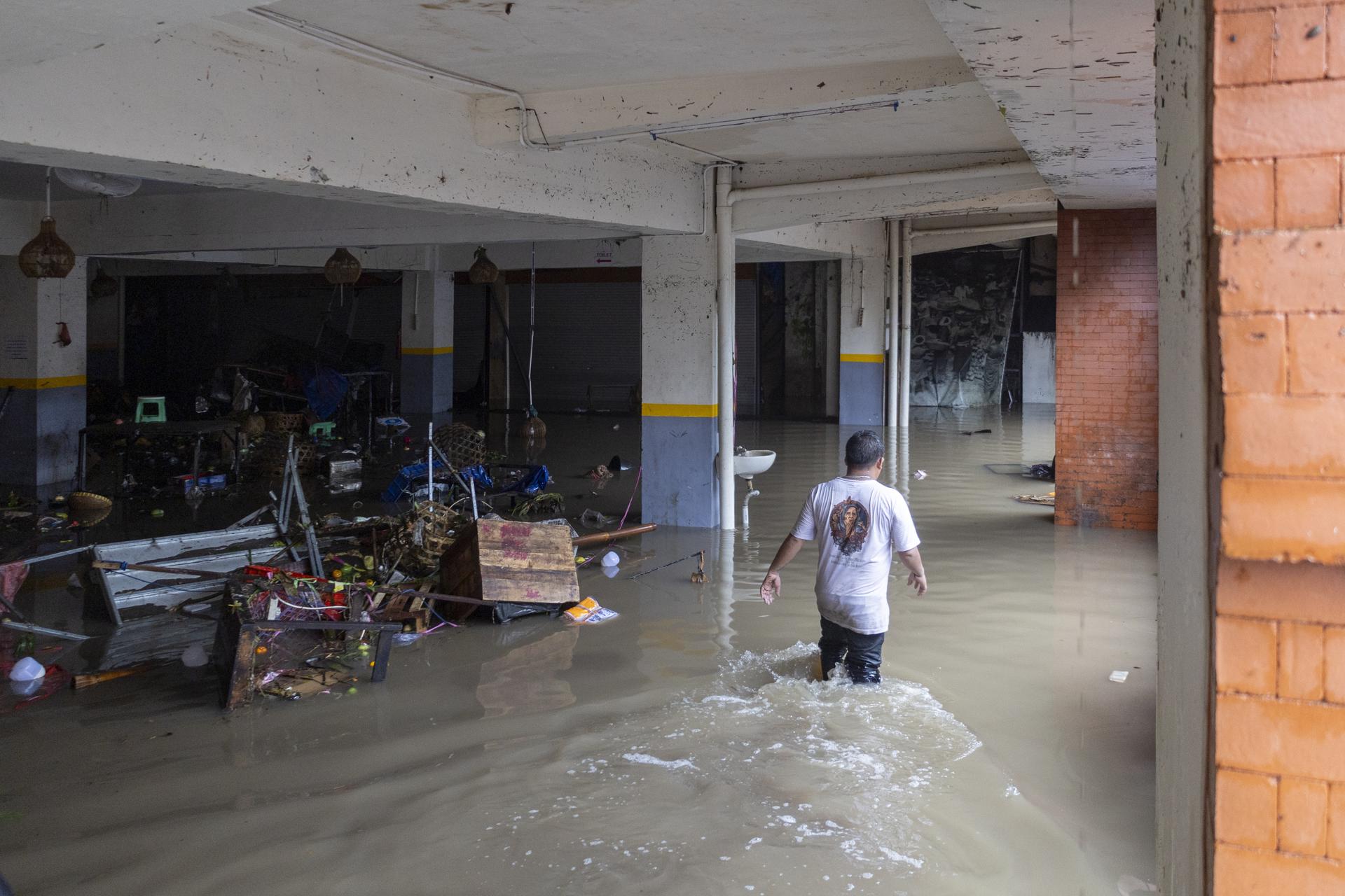 Un hombre camina entre el agua de las inundaciones en Denpasar, Bali (Indonesia) este miércoles. EFE/EPA/MADE NAGI
