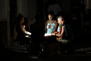 Fotografía de archivo, tomada el pasado 23 de agosto, en la que se captó a un grupo de personas al jugar dominó en medio de sin iluminación eléctrica, durante uno de los apagones diarios, en La Habana (Cuba). EFE/Ernesto Mastrascusa