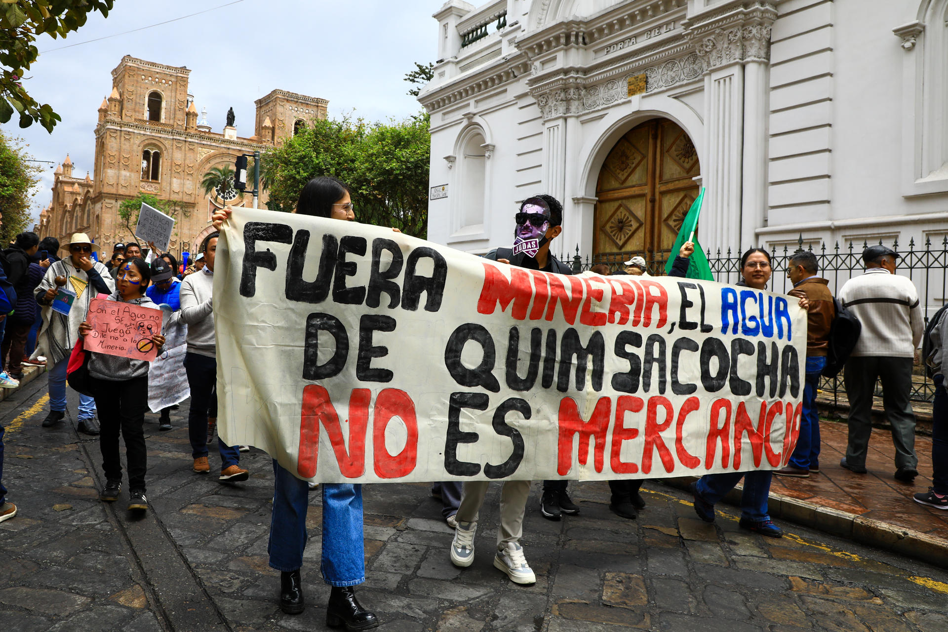 Fotografía de archivo en donde se ven personas que muestran un cartel durante una manifestación contra el proyecto minero Loma Larga, en Cuenca (Ecuador). EFE/ Robert Puglla