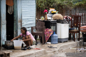 Una mujer recoge sus pertenencias luego de una inundación este viernes, en Azua (República Dominicana). EFE/ Orlando Barría