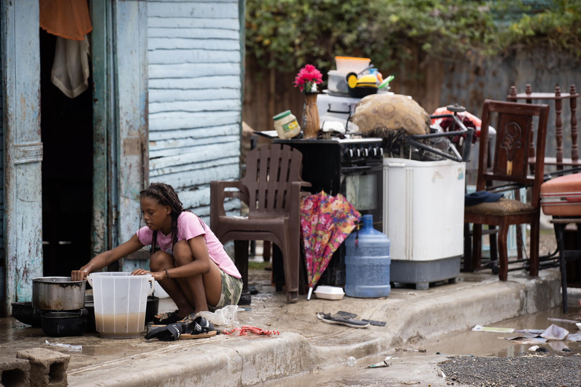 Una mujer recoge sus pertenencias luego de una inundación este viernes, en Azua (República Dominicana). EFE/ Orlando Barría