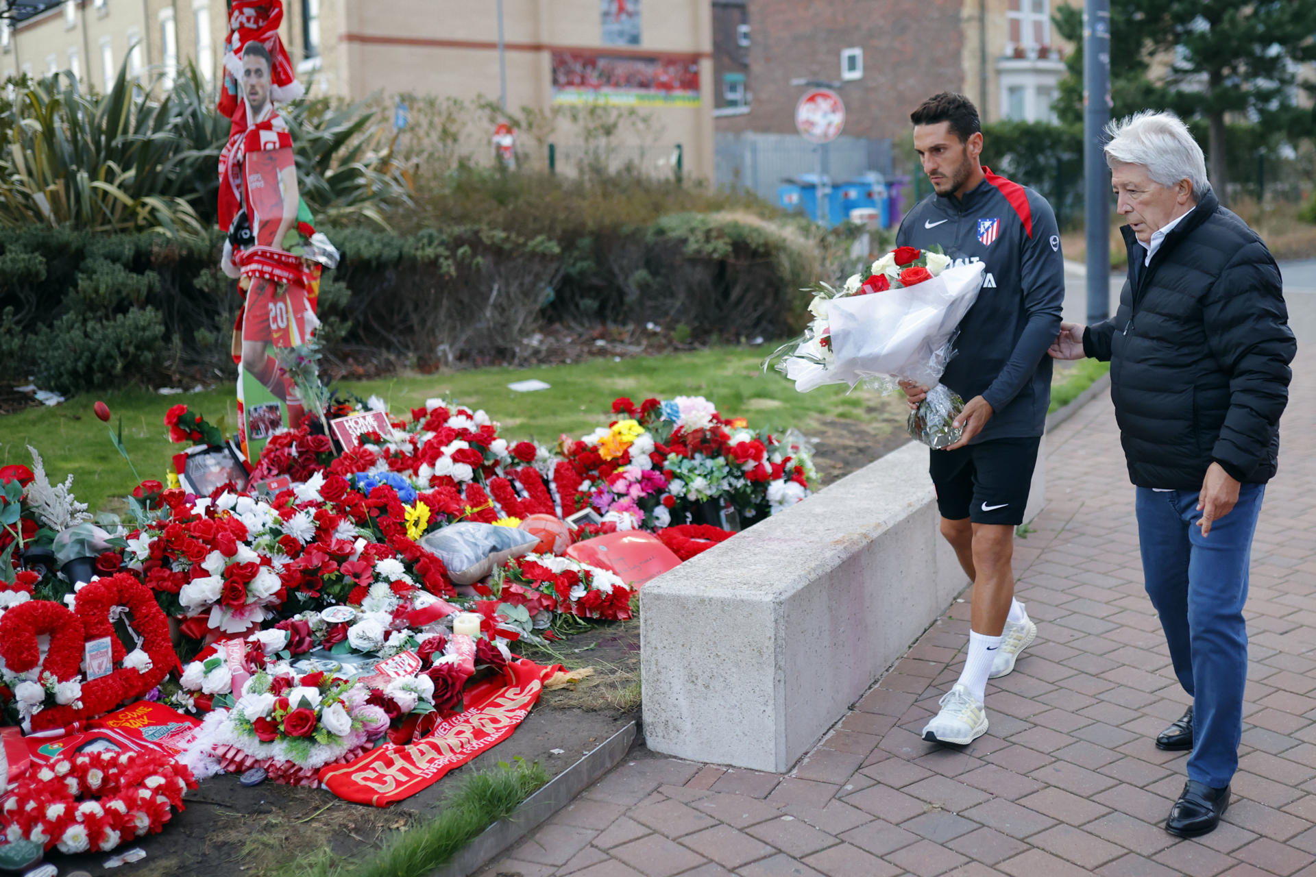 El jugador y el presidente del Atlético de Madrid, Koke y Enrique Cerezo (d), colocan un ramo de flores en recuerdo del jugador portugués del Liverpool, Diogo Jota, previo al encuentro que disputan mañana miércoles en la ciudad inglesa. .- Cerezo y Koke depositan unas flores en recuerdo de Diiogo Jota. EFE / Atlético de Madrid.