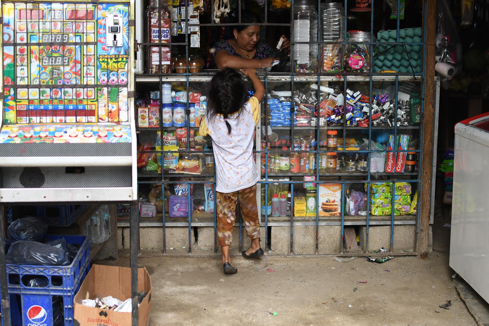 Fotografía del 10 de septiembre de 2025 de Lucky Vasquez (arriba), atendiendo una tienda en Chinautla (Guatemala). EFE/Mariano Macz
