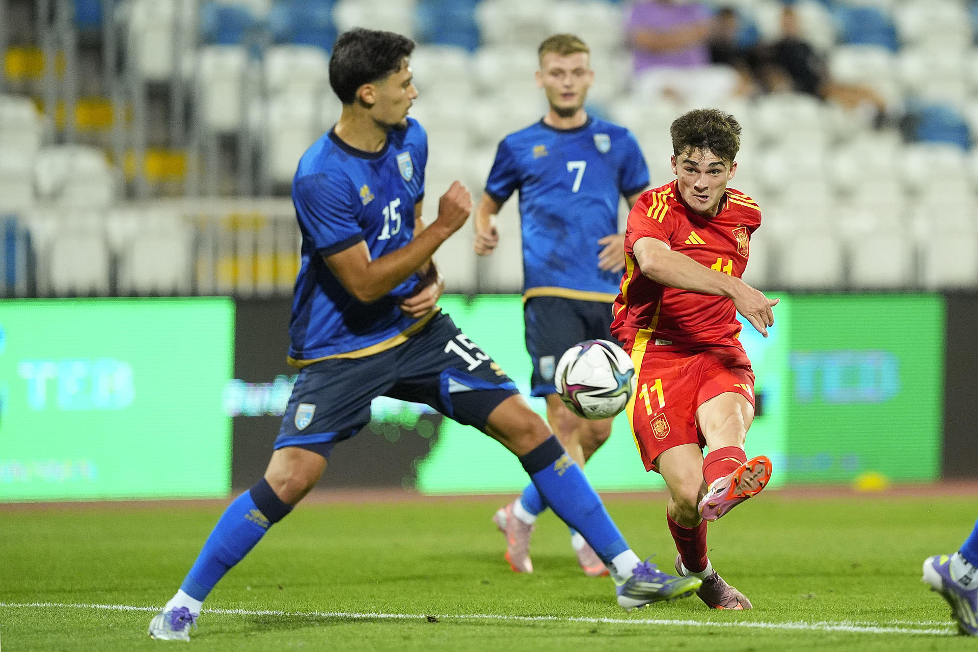 El delantero de la selección española de fútbol sub-21 Joel Roca (d) dispara a puerta ante Lendrit Shala, de la selección de Kosovo, durante el partido de la fase de clasificación del próximo Europeo sub-21 que los dos combinados nacionales juegan este martes en el estadio Fadil Vokrri, en Pristina. EFE/RFEF/Acero
