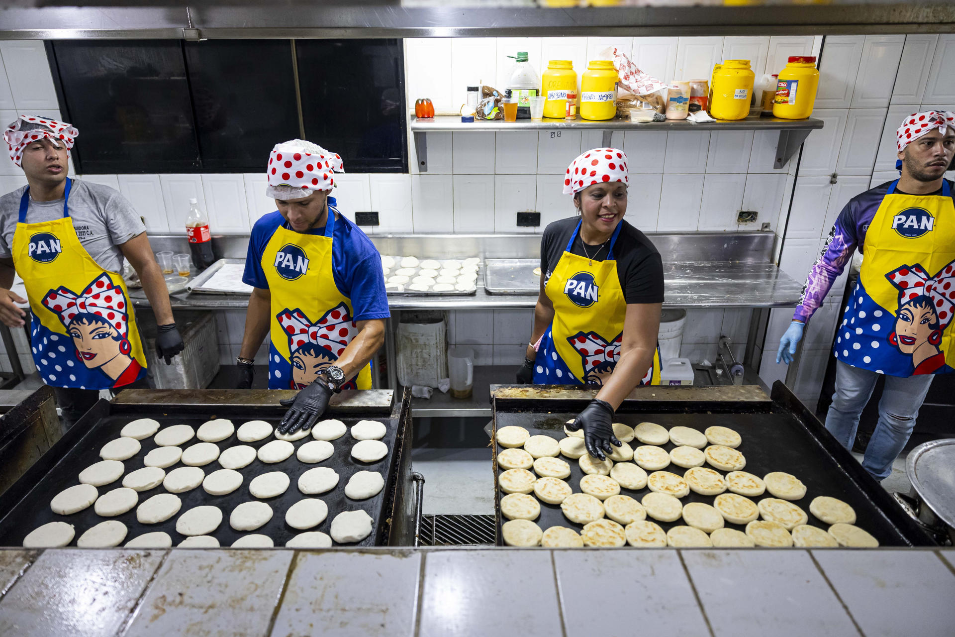 Personas preparan arepas este sábado, en Caracas (Venezuela). EFE/ Miguel Gutierrez
