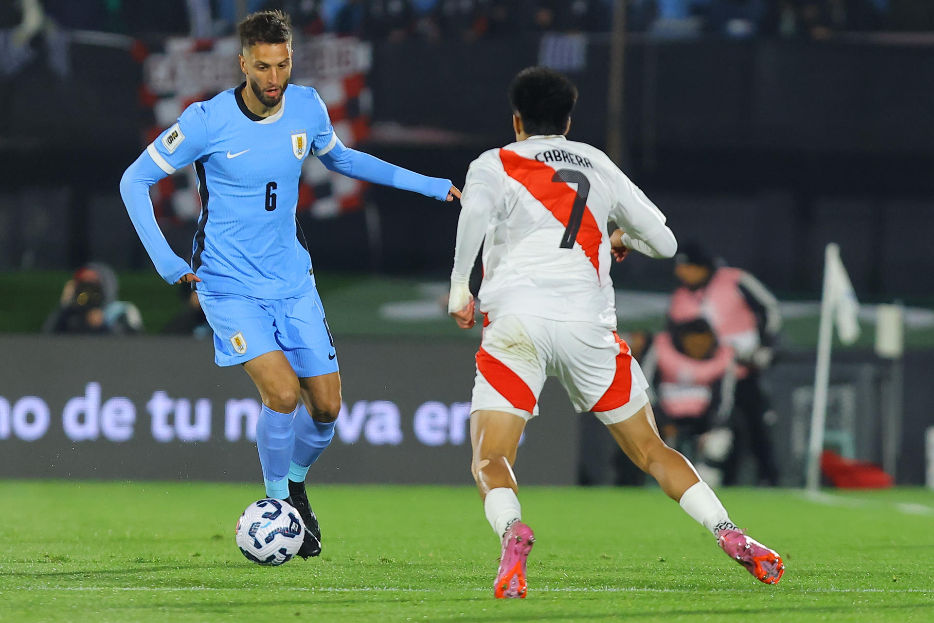 Rodrigo Bentancur (i), de Uruguay, disputa el balón con Kenji Cabrera, de Perú, en un partido por las eliminatorias a la Copa Mundial 2026 entre Uruguay y Perú en el estadio Centenario en Montevideo (Uruguay) EFE/ Gastón Britos
