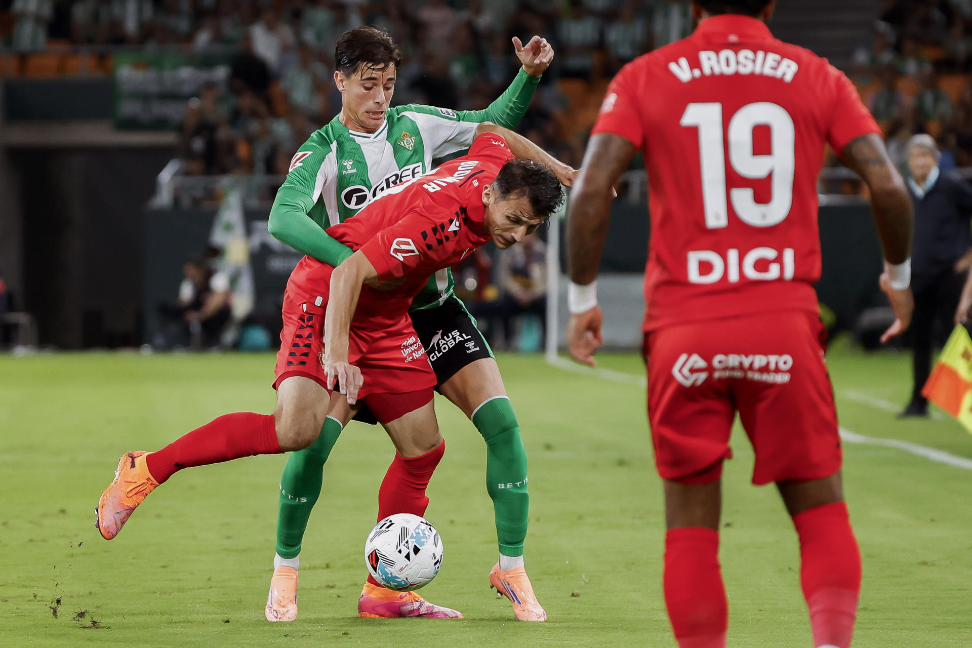 Budimir, del Osasuna, lucha un balón con Valentín (detrás), del Real Betis, durante el partido de Laliga que Betis y Osasuna disputaron en el estadio de La Cartuja. EFE/Julio Muñoz