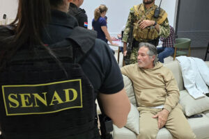 Fotografía cedida por la Secretaría Nacional Antidrogas que muestra a integrantes de las Fuerzas Armadas custodiando al presunto líder del grupo criminal La Barredora, Hernán Bermúdez Requena, este sábado en Mariano Roque Alonso (Paraguay). EFE/ Secretaría Nacional Antidrogas de Paraguay